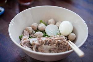 thailändska nudlar med fläsk och köttbullar i en vit skål