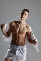 atletisk kille med muskel magmuskler handduk på tillbaka vit shorts Framställ foto