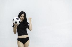 ung skön asiatisk kvinna ha på sig fotboll spelare heja på sport, kvinnlig fläktar fotboll glädjande spel foto