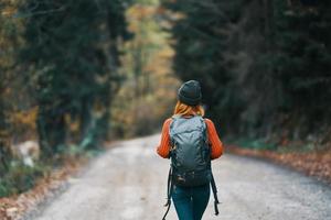 resande med en ryggsäck i de skog på de väg i höst träd modell foto