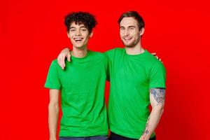 två vänner kramas i grön t-tröjor vänskap team kommunikation foto