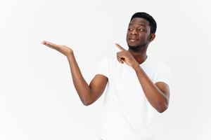 en stilig kille av afrikansk utseende gester med hans händer på en ljus bakgrund foto