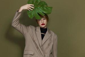 porträtt av en kvinna röd mun handflatan blad charm mode grön bakgrund foto