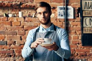 manlig servitör förkläde kaffe kopp professionell arbete livsstil foto