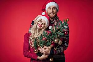 porträtt av en ung par i ett omfamning Semester jul röd bakgrund foto