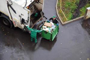 sopor avlägsnande i bostads- område, sopor män läser in hushåll skräp i sopor lastbil foto
