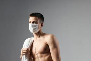 söt kille i medicinsk mask naken axlar träna handdukar Gym foto