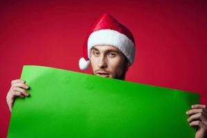 glad man i en jul hatt med grön attrapp röd bakgrund foto