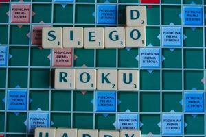 lyckönskningar för de ny år anordnad med brev putsa på de spel styrelse i scrabble foto