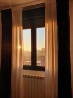 bakgrund en fönster med gardiner genom som de stigande Sol kommer i foto