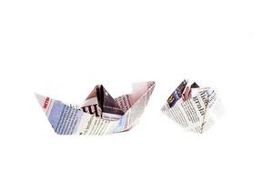 origami fartyg från tidning på vit bakgrund foto