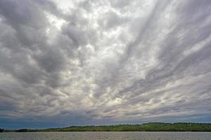 hotande stratus moln över en vildmark sjö foto