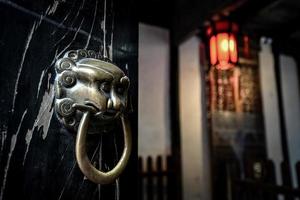 traditionell lejon form dörr knocker i gammal hus i gammal kinesisk stad foto