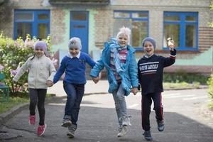 belarus, de stad av gomel, Maj 10, 2019. öppen dag i dagis.glad förskolebarn på de gata. barn innehav händer Hoppar. en grupp av sex år gammal vänner. foto