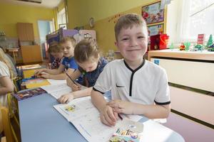 barn i en teckning lektion i dagis. preschooler med penna och anteckningsbok foto