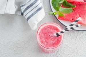 friska vattenmelon dryck eller smoothie och färsk vattenmelon på ljus betong bakgrund. sommar dryck begrepp. topp se, kopia Plats foto