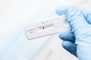 läkare innehav en negativ resultat för covid-19 med testa utrustning för viral sjukdom. foto