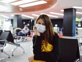 kvinna i medicinsk mask passagerare flygplats bagage foto