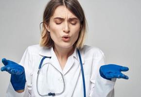 kvinna läkare i en medicinsk klänning blå handskar stetoskop arbete en sjuksköterska foto