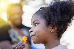 unge med ringa pop- godis i parkera, flicka njut av med ringa godis poppar foto