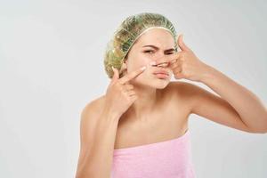 kvinna bar axel dusch keps ansikte hud vård foto