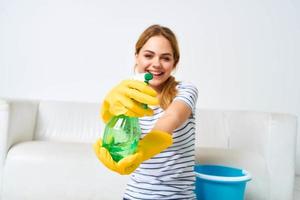 kvinna med rengöringsmedel i händer hushållsarbete interiör hygien foto