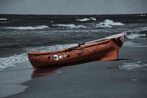 ett orange livräddare båt på en strand i leba i polen på en värma dag foto