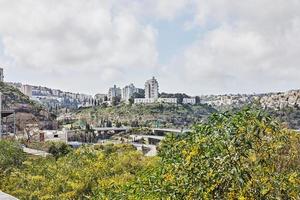 väg korsning i haifa stad och stad byggnader i grönska i vår foto