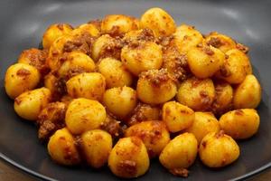 italiensk Gnocchi di patate, potatis Gnocchi, med bolognese sås. foto