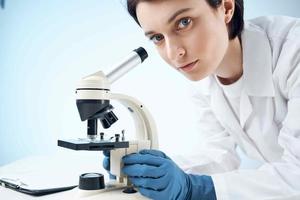 kvinna laboratorium assistent ser mikroskop diagnostik professionell vetenskap foto