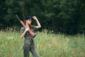 kvinna på utomhus- kvinna med vapen grön overall svart keps färsk luft foto
