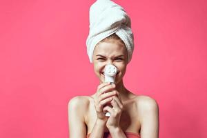 kvinna med bar axlar rengöring hud spa behandlingar rosa bakgrund foto