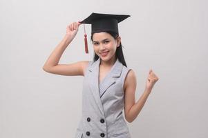 ung leende kvinna bär gradering hatt, utbildning och universitet begrepp foto