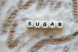 socker på tabell bakgrund, vit socker för mat och sötsaker efterrätt godis högen av ljuv socker kristallin granulerad foto