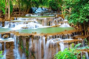 Fantastisk färgrik vattenfall i nationell parkera skog under vår, vackert djup skog i thailand, teknik lång exponering, under semester och koppla av tid. foto