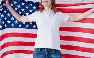 vit polo skjorta på kvinna över USA flagga bakgrund, attrapp design foto
