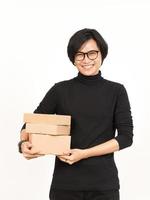 innehav paket låda eller kartong låda av stilig asiatisk man isolerat på vit bakgrund foto