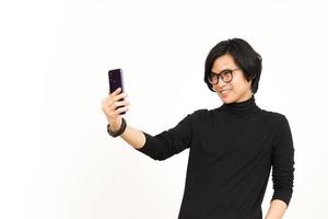 ta en selfie använder sig av smartphone av stilig asiatisk man isolerat på vit bakgrund foto