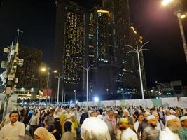 mecka, saudi Arabien, april 2023 - en stor siffra av pilgrimer från Allt över de värld samla på de yttre väg nära masjid al-haram, mecka på natt. foto