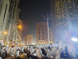 mecka, saudi Arabien, april 2023 - en skön se av pilgrimer, lång byggnader och lampor på natt på de yttre väg i masjid al-haram, mecka. foto