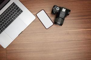en bärbar dator och en kamera på en trä- tabell foto