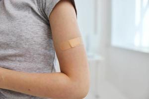 plåster på en kvinnas hand närbild vaccin pass foto