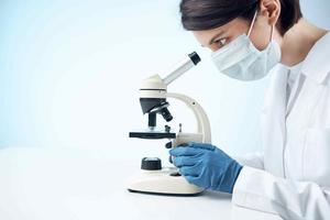 kvinna laboratorium assistent medicinsk mask mikroskop diagnostik bioteknik foto