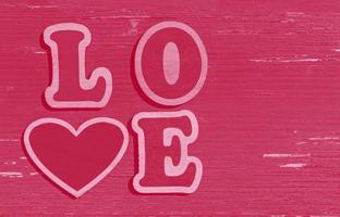 rosa valentines dag bakgrund, ord kärlek tillverkad av trä- brev foto