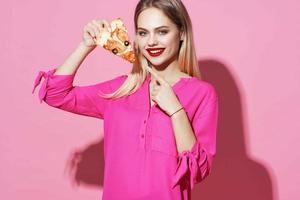 blond äter pizza snabb mat rosa bakgrund foto