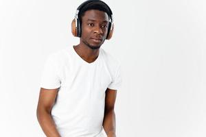 afrikansk amerikan med hörlurar lyssnande till musik livsstil teknologi ljus bakgrund foto