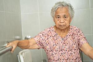 asiatisk senior kvinna patient använda sig av toalett badrum hantera säkerhet i amning sjukhus, friska stark medicinsk begrepp. foto