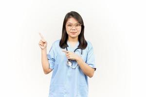 som visar produkt och pekande sida av asiatisk ung läkare isolerat på vit bakgrund foto