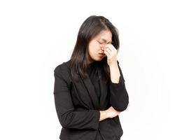 lidande huvudvärk av skön asiatisk kvinna bär svart blazer isolerat på vit bakgrund foto