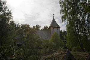 historisk trä- kyrka bland höst träd i polen foto